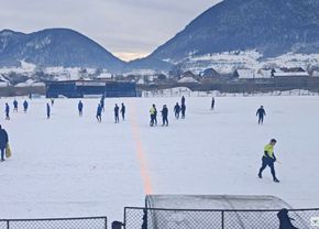 meci-intr-un-decor-pitoresc-in-romania-gazon-acoperit-de-zapada,-minge-verde-si-munti-de-jur-imprejur
